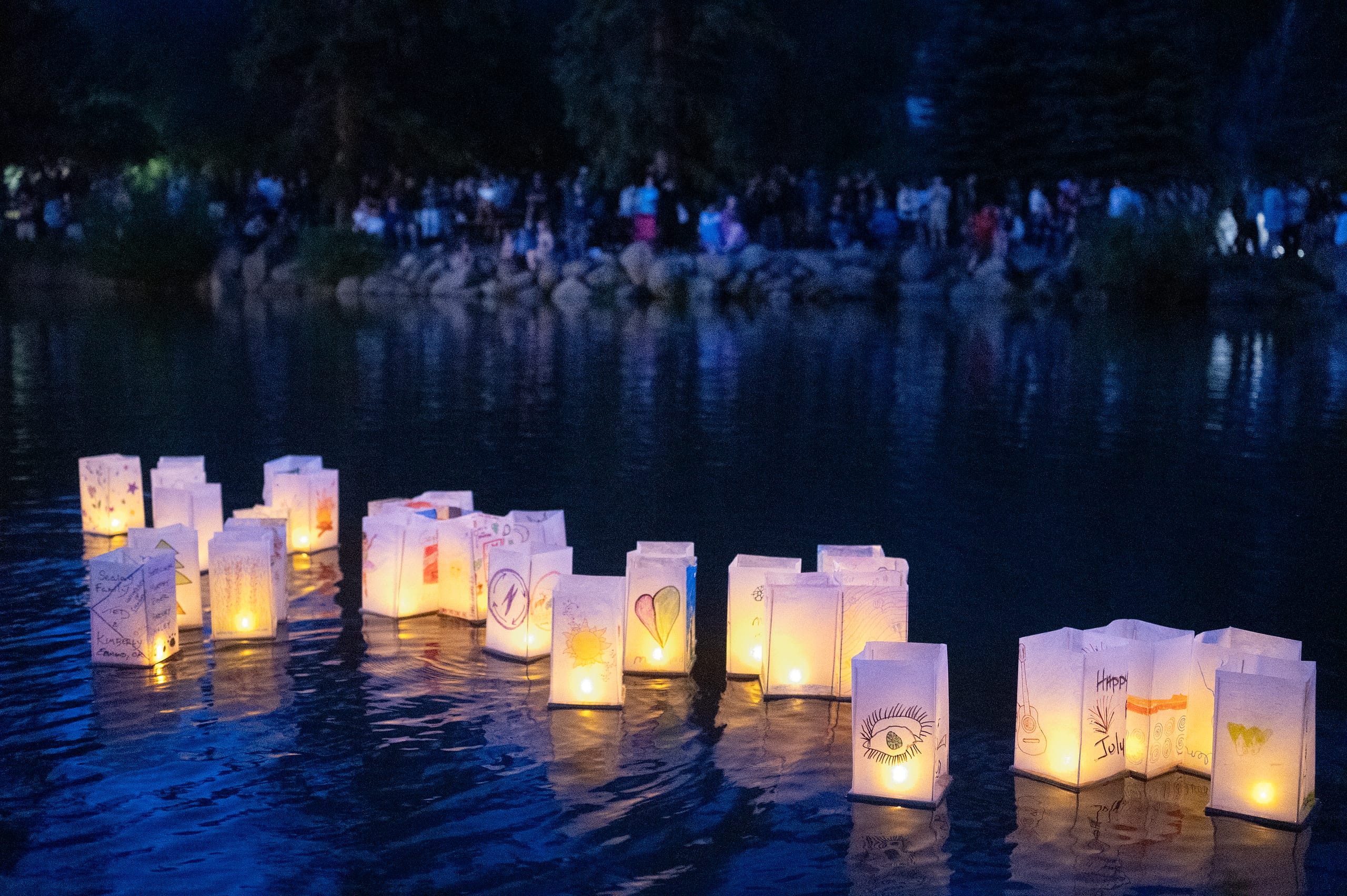 Water lanterns floating on water at nighttime.